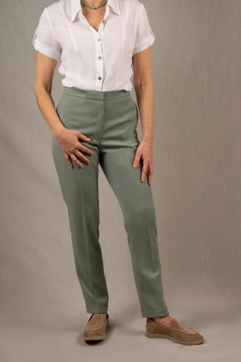 Pantalon femme tailleur 100% laine. Coupe légèrement fittée, pourvu de deux poches à l’Italienne sur le devant et une poche passepoilée fermée par un bouton à l’arrière.