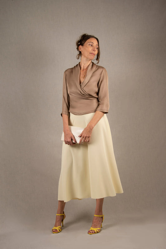 Cette jupe a une coupe longue et évasée, également pourvue d'une taille haute. Elle a un tombé fluide. Elle a une fermeture zippée invisible à l'arrière avec une agrafe métallique de maintien à la taille.