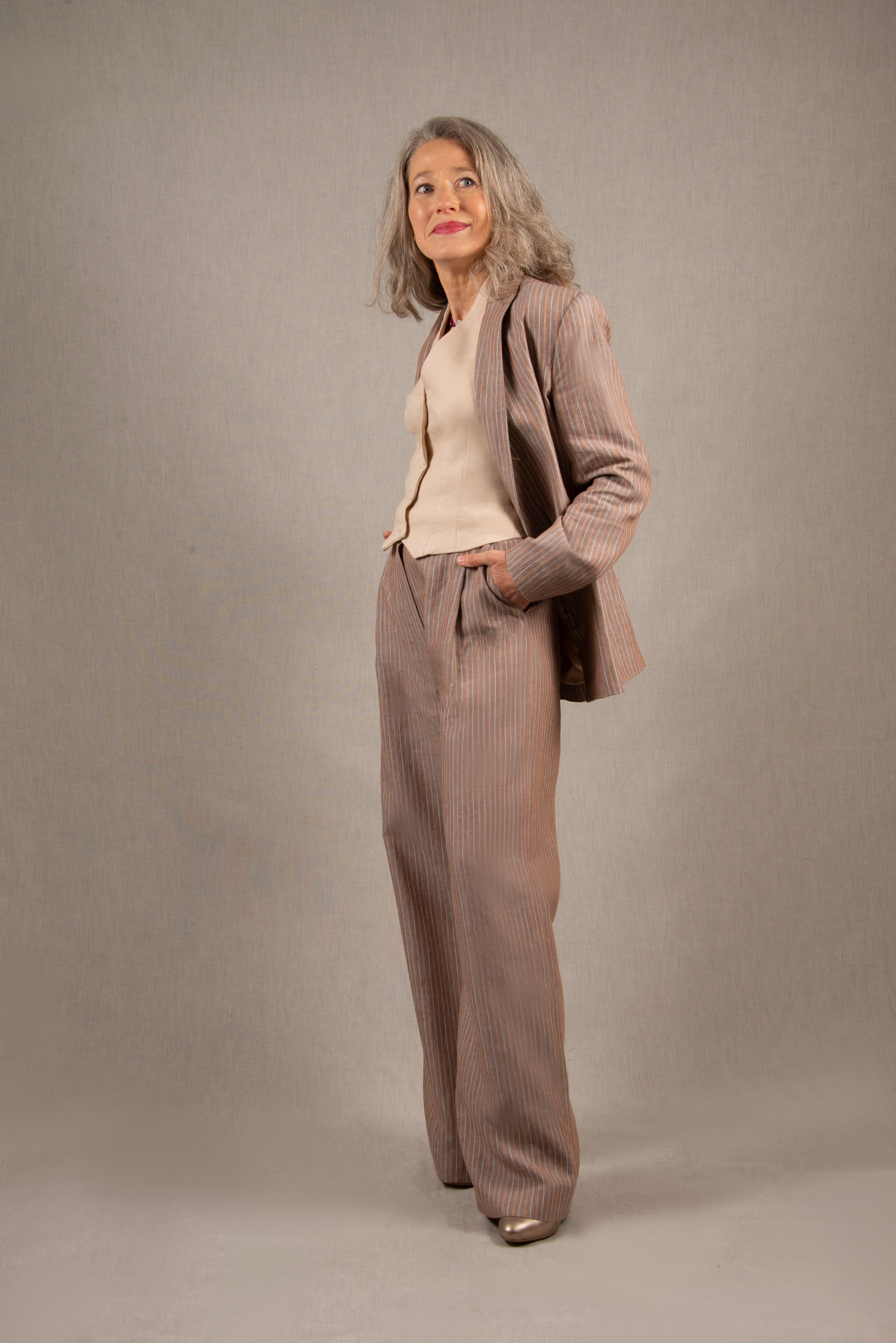 Ce pantalon en lin a une coupe fluide large, avec un pli sur le devant et pourvu de deux poches à l’Italienne et d’une ceinture à passants. Sa ceinture est bordée à l’intérieur d’un biais en coton contrasté.