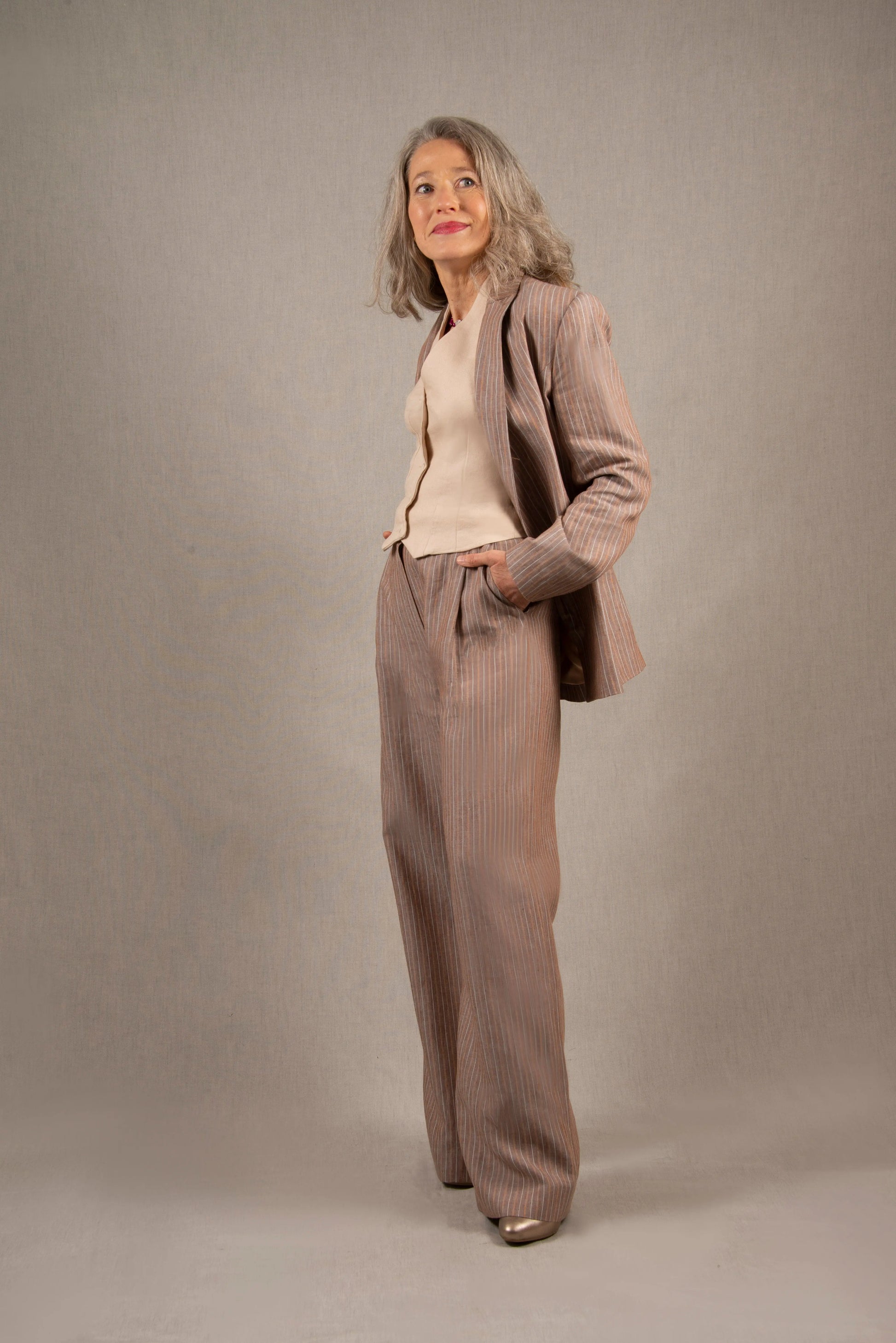 Ce pantalon en lin a une coupe fluide large, avec un pli sur le devant et pourvu de deux poches à l’Italienne et d’une ceinture à passants. Sa ceinture est bordée à l’intérieur d’un biais en coton contrasté.