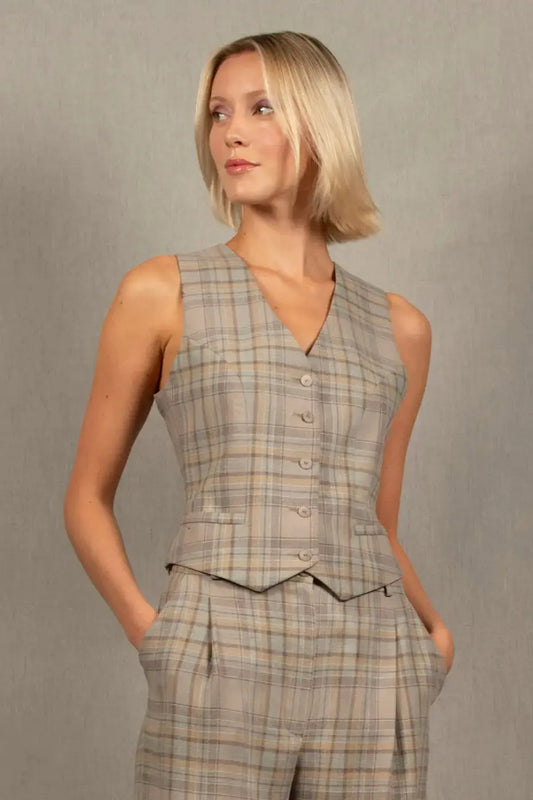 Gilet tailleur femme en 100% laine, à carreaux.  Cinq boutons en nacre mates ton sur ton sur le devant, ainsi que deux poches passepoilées. La coupe de ce gilet est cintrée. La doublure est en 100% viscose avec un coloris ambré.