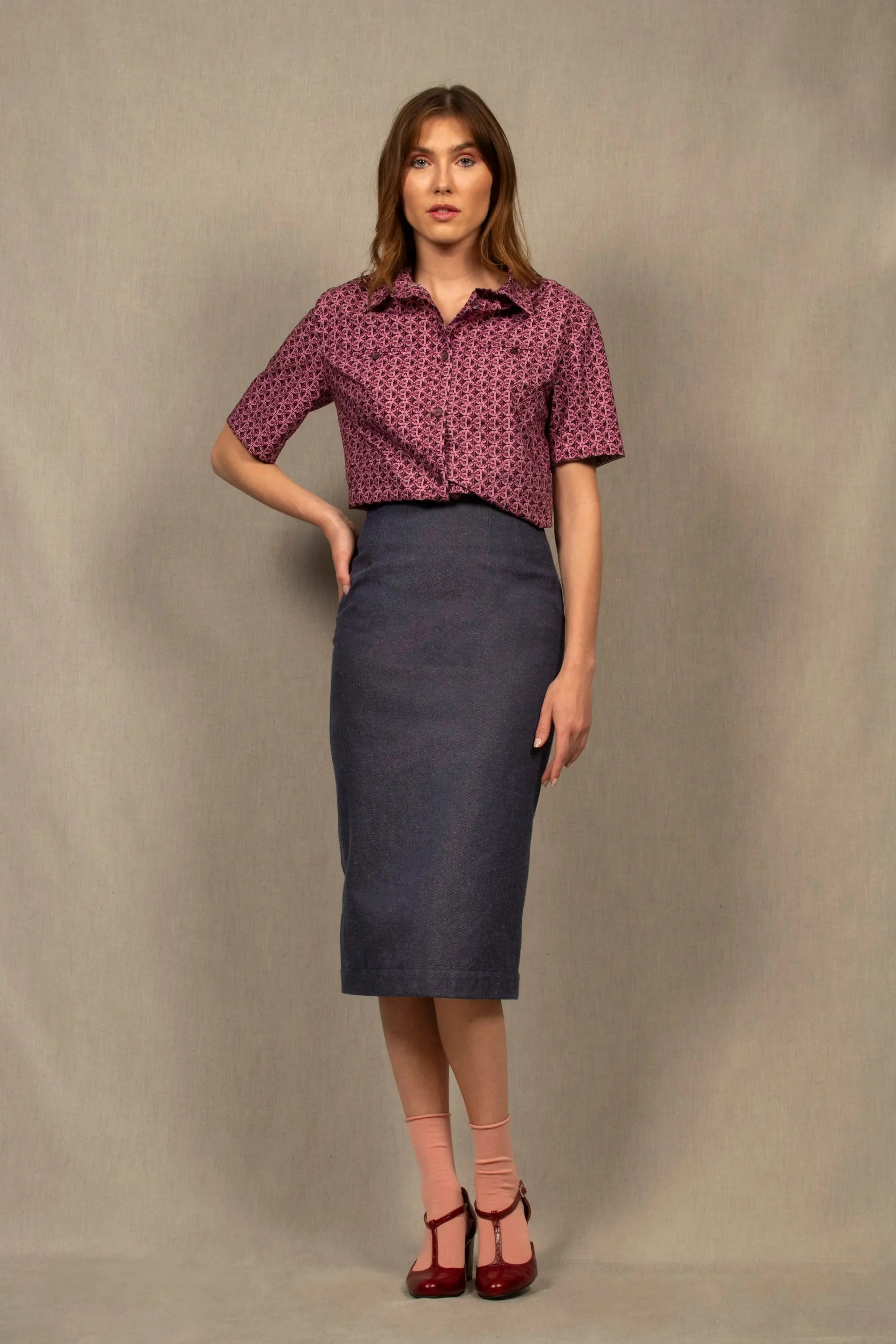 Cette jupe à la coupe crayon et à la longueur mi-mollet, a de nombreuses pinces devant et dos permettant d’affiner la taille. 