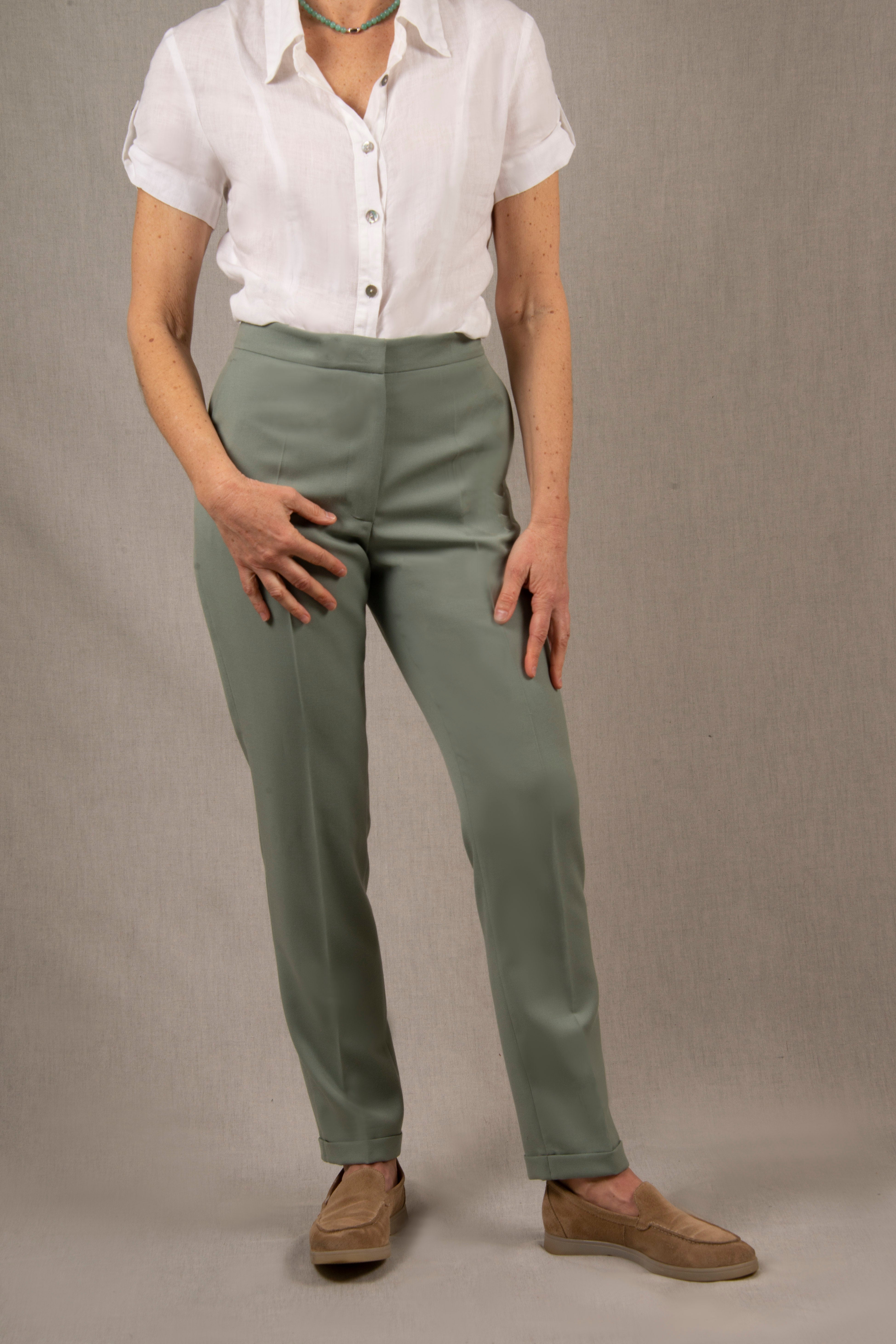 Pantalon femme tailleur 100% laine. Coupe légèrement fittée, pourvu de deux poches à l’Italienne sur le devant et une poche passepoilée fermée par un bouton à l’arrière. 