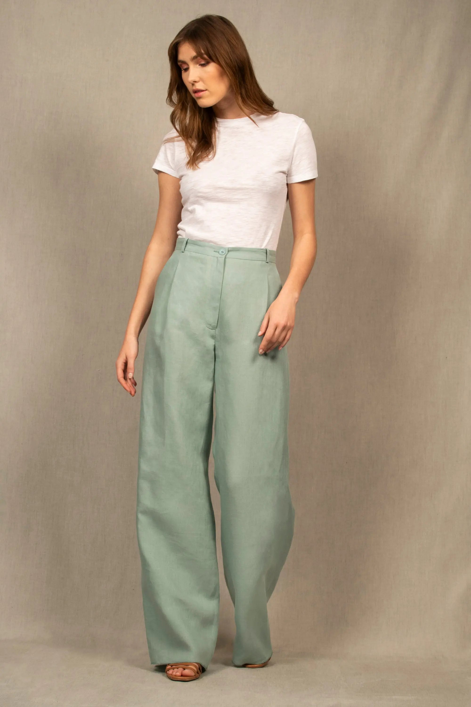 Ce pantalon en lin a une coupe fluide et large. Il présente un pli sur le devant, et est pourvu de deux poches à l’Italienne et d’une ceinture à passants. Sa ceinture est étroite et bordée à l’intérieur d’un biais en coton contrasté.