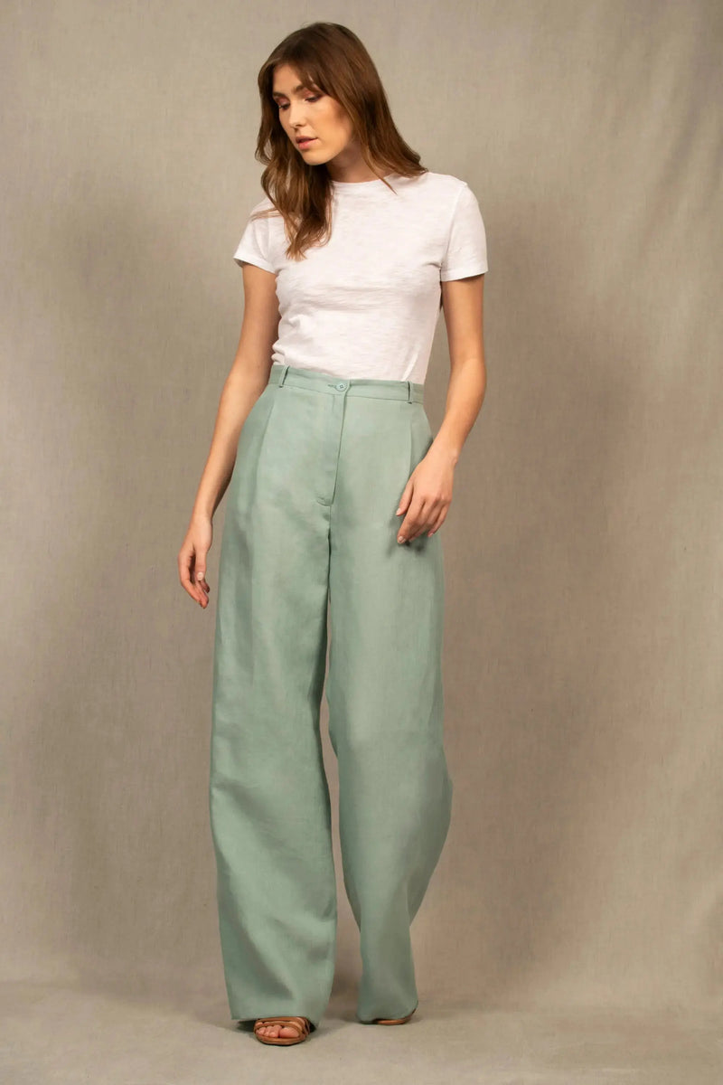 Ce pantalon en lin a une coupe fluide et large. Il présente un pli sur le devant, et est pourvu de deux poches à l’Italienne et d’une ceinture à passants. Sa ceinture est étroite et bordée à l’intérieur d’un biais en coton contrasté.