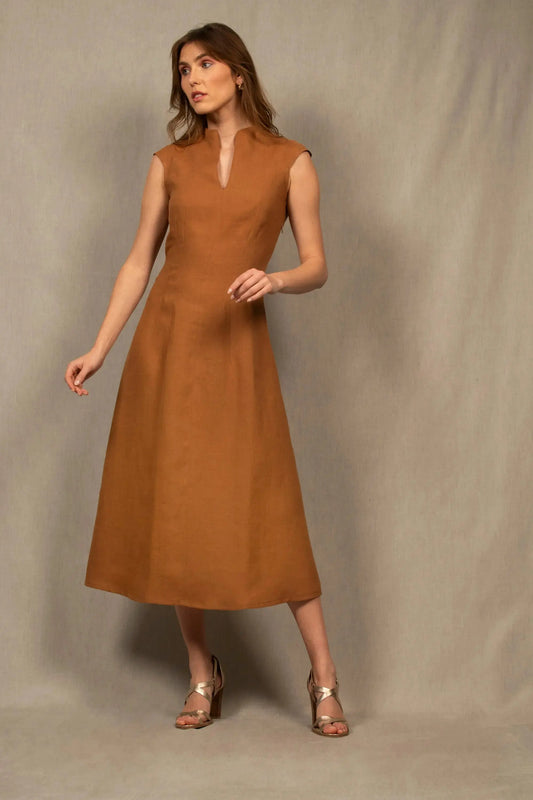 Robe en lin, couleur cognac,  légèrement évasée longueur à la cheville. La taille est marquée par un jeu de pinces. Il y a un ouverture dans le bas du dos au niveau de la taille. Fermeture par zip invisible côté gauche. Col légèrement montant avec fente milieu devant.