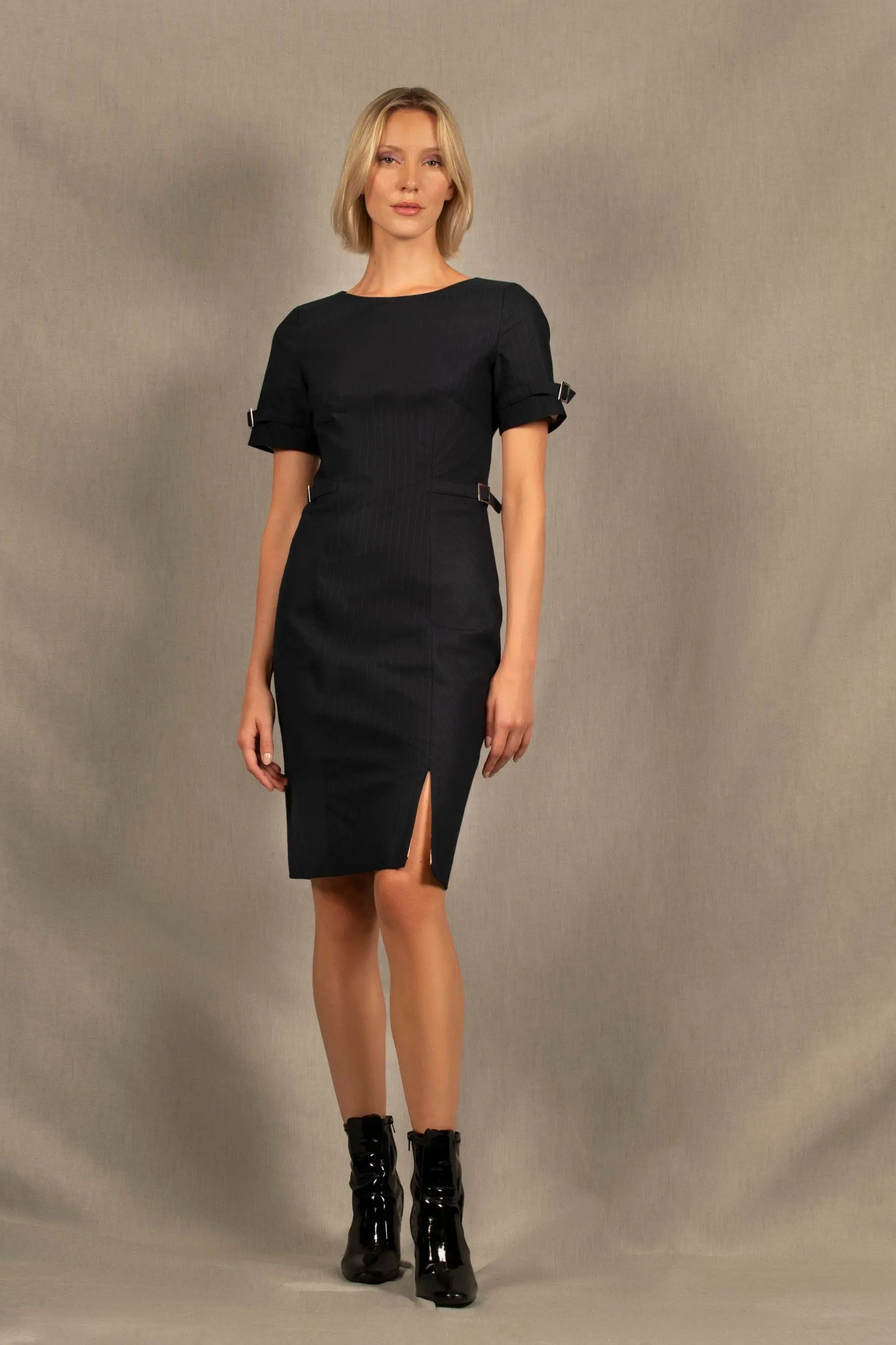 Cette robe en coton couleur bleu marine a une coupe cintrée mi-longue avec encolure ronde, découpes structurantes devant et dos, petite fente sur le côté gauche et fermeture zippée au milieu du dos.