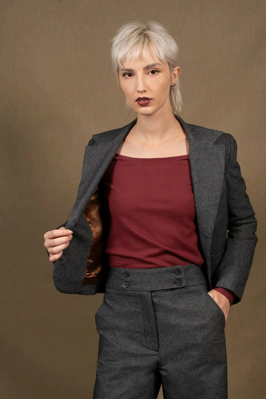 Cette veste femme courte marque la taille. Elle présente des découpes princesses sur le dos et le devant. Elle a deux fentes dans le dos pour accentuer la cambrure. Fermée par une série de 3 boutons irisés reportés également sur le bas des manches, ainsi que deux petites poches plaquées agrémentent le devant.