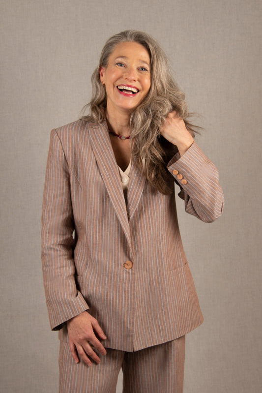 Confectionné en 100% lin, cette veste est légèrement cintrée, mi-longue et à entoilage léger. Elle comporte deux poches à un passepoil sur le devant. Son boutonnage est simple. Il y a une fente dans le dos et elle se ferme sur le devant par un bouton. Son col est étroit.