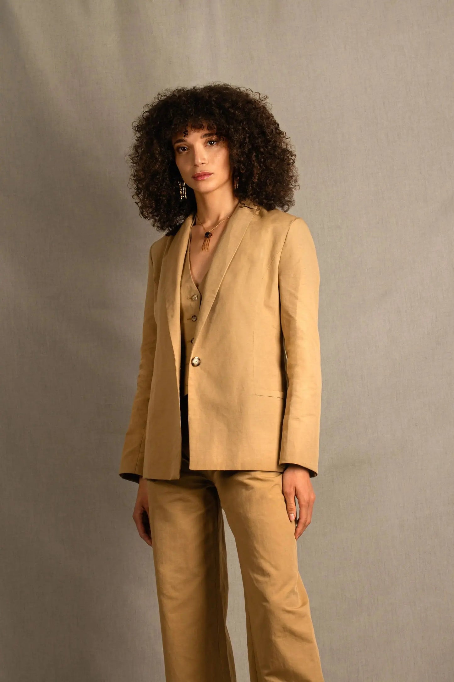 Confectionné en 100% lin, cette veste est légèrement cintrée, mi-longue et à entoilage léger. Elle comporte deux poches à un passepoil sur le devant. Son boutonnage est simple. Il y a une fente dans le dos et elle se ferme sur le devant par un bouton. Son col est étroit.